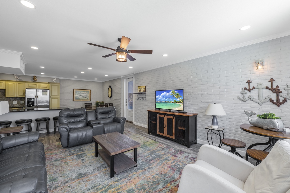 Your spacious open-concept living area features plush leather seating, smart TV, and kitchen access for perfect vacation relaxation.