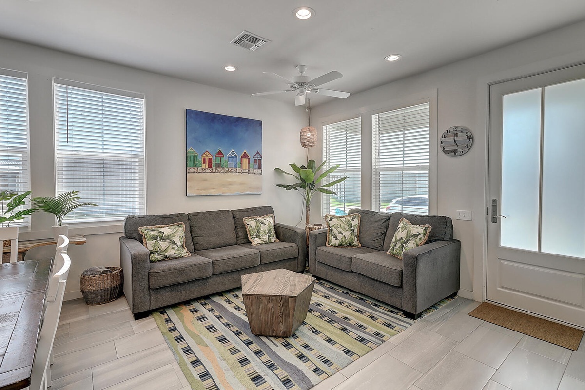 Sink into plush sofas in your bright living room, where tropical artwork and natural light create the perfect retreat for relaxation.