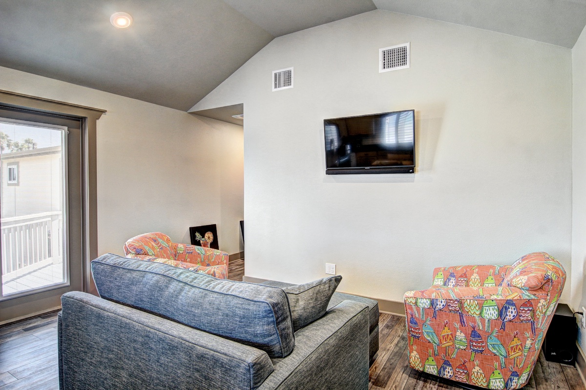 Unwind in your spacious living area with plush seating and wall-mounted TV for cozy evenings after exploring the city.