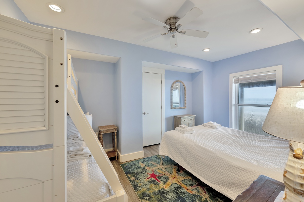 Your peaceful bedroom features soft blue walls, fresh linens, and bunk beds perfect for families or friends sharing memories together.