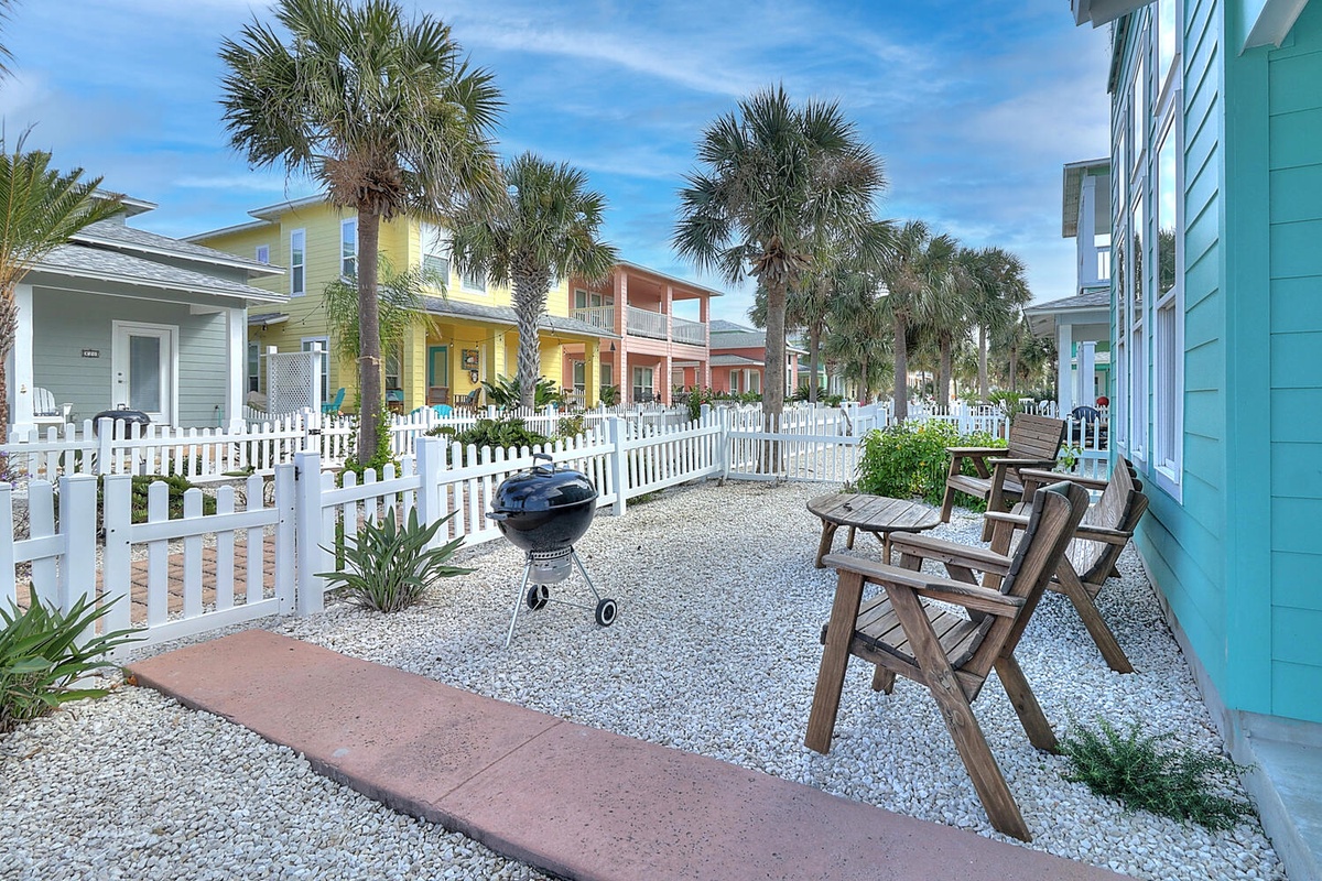 Fire up your own BBQ and relax on weathered wood chairs in your private gravel courtyard, surrounded by tropical palms and colorful beach cottage charm.