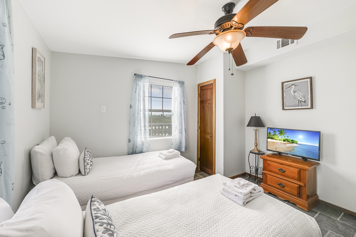 Drift off to sleep in your twin bed sanctuary, with crisp linens and a ceiling fan for perfect comfort.