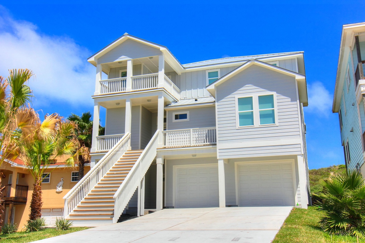 Stunning coastal vacation home with modern design and tropical landscaping in a prime beachside location.