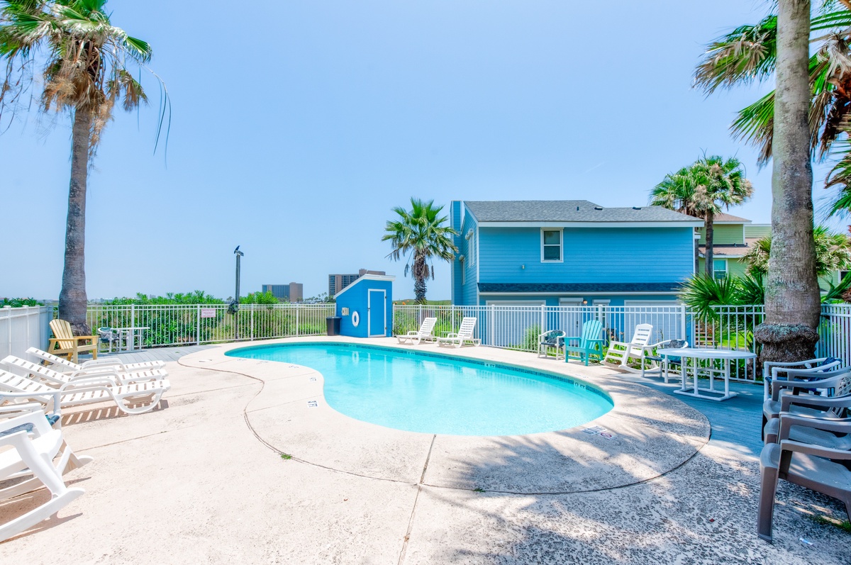 Dive into your private tropical paradise with crystal-clear pool waters surrounded by swaying palms and comfortable loungers.