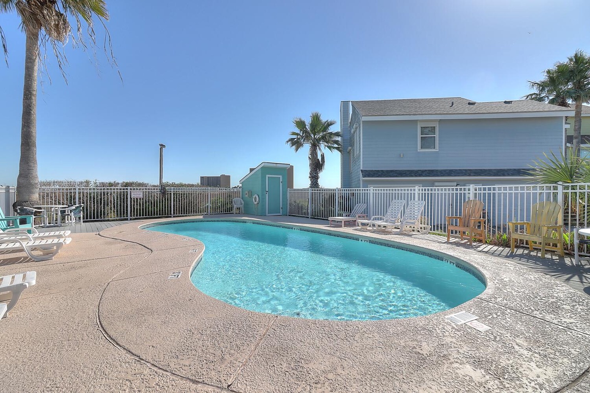 Dive into your private pool oasis, surrounded by swaying palms and colorful lounge chairs under endless blue skies.