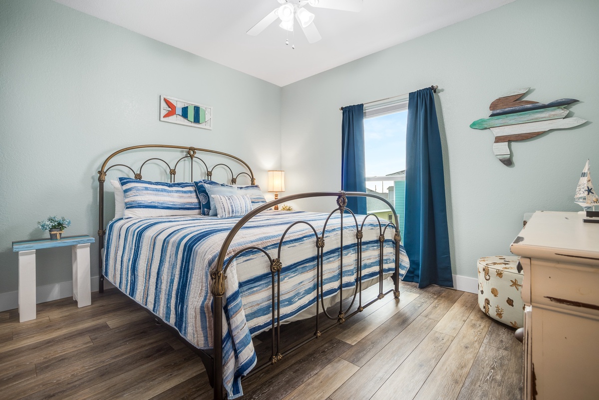 Drift off to sleep in your charming coastal bedroom, featuring a brass bed with ocean-inspired linens and peaceful water views.