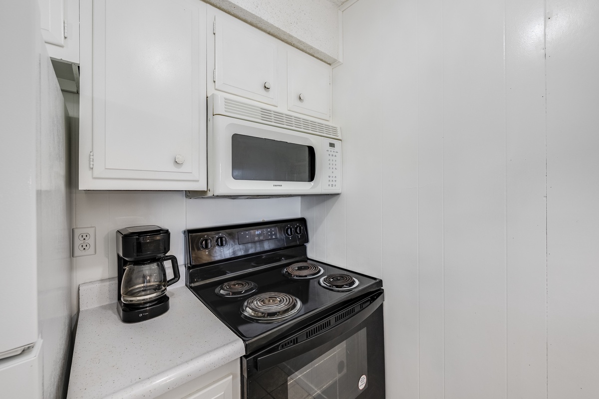 Your fully equipped kitchen features a microwave, electric stove, and coffee maker ready for your morning brew and home-cooked meals.