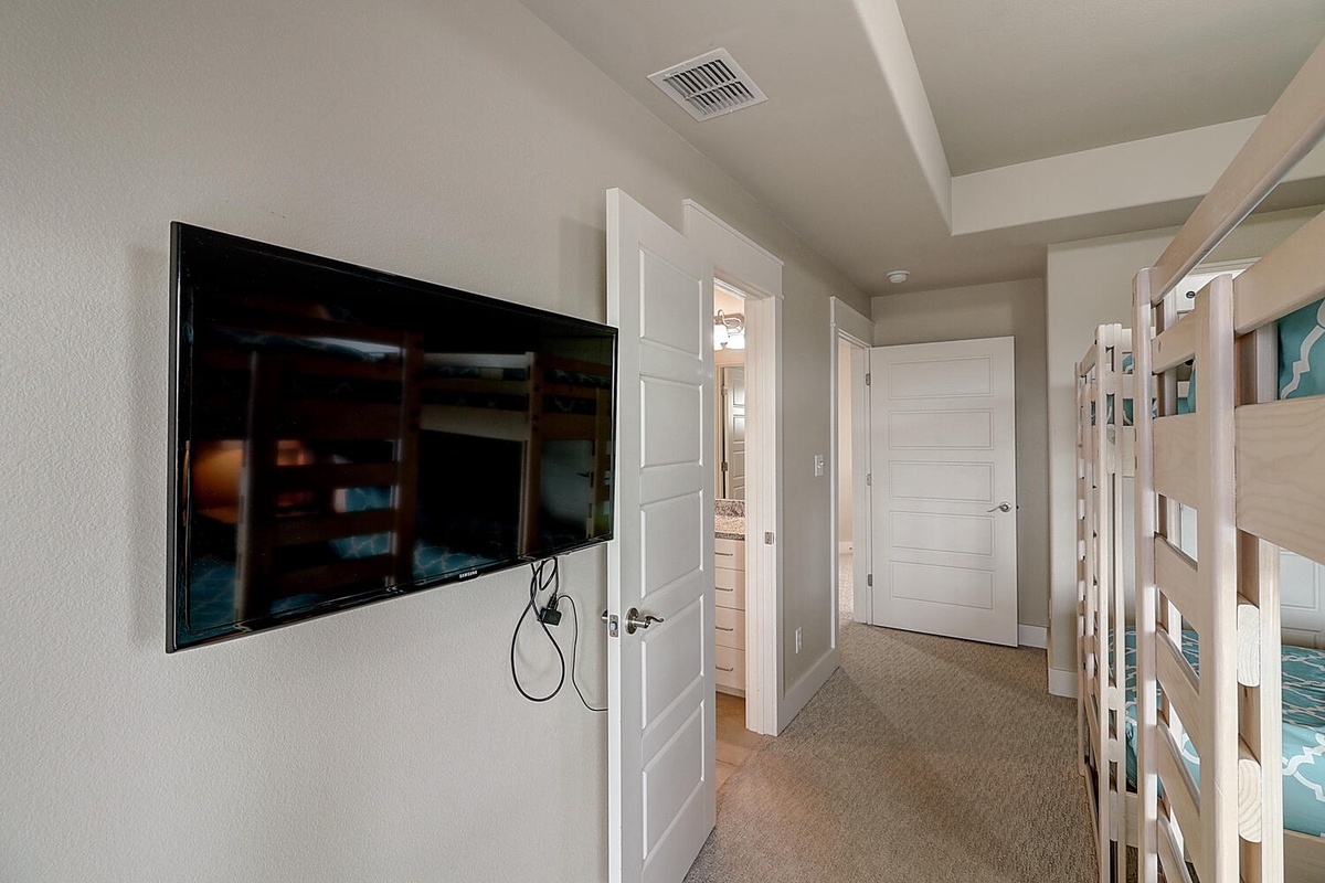 Your cozy bedroom features a wall-mounted TV for movie nights and bunk beds perfect for family stays or groups.