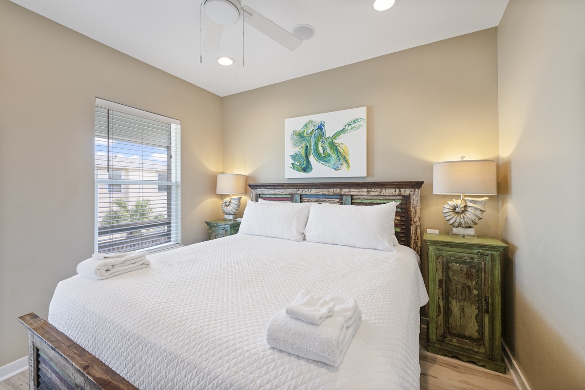 Your peaceful bedroom retreat awaits with crisp linens, rustic coastal charm, and soft lighting that creates the perfect ambiance for restful nights away from home.