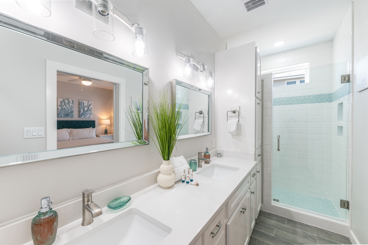 Indulge in your spa-like ensuite bathroom, featuring dual vanities with pristine lighting and a luxurious glass-enclosed shower for the ultimate refresh.