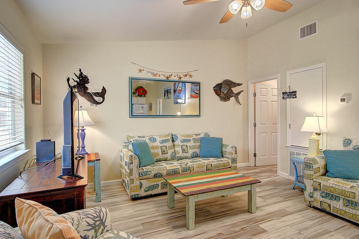 Relax in your cheerful living room with nautical touches, where coastal charm meets comfort beneath the gentle whir of ceiling fan.
