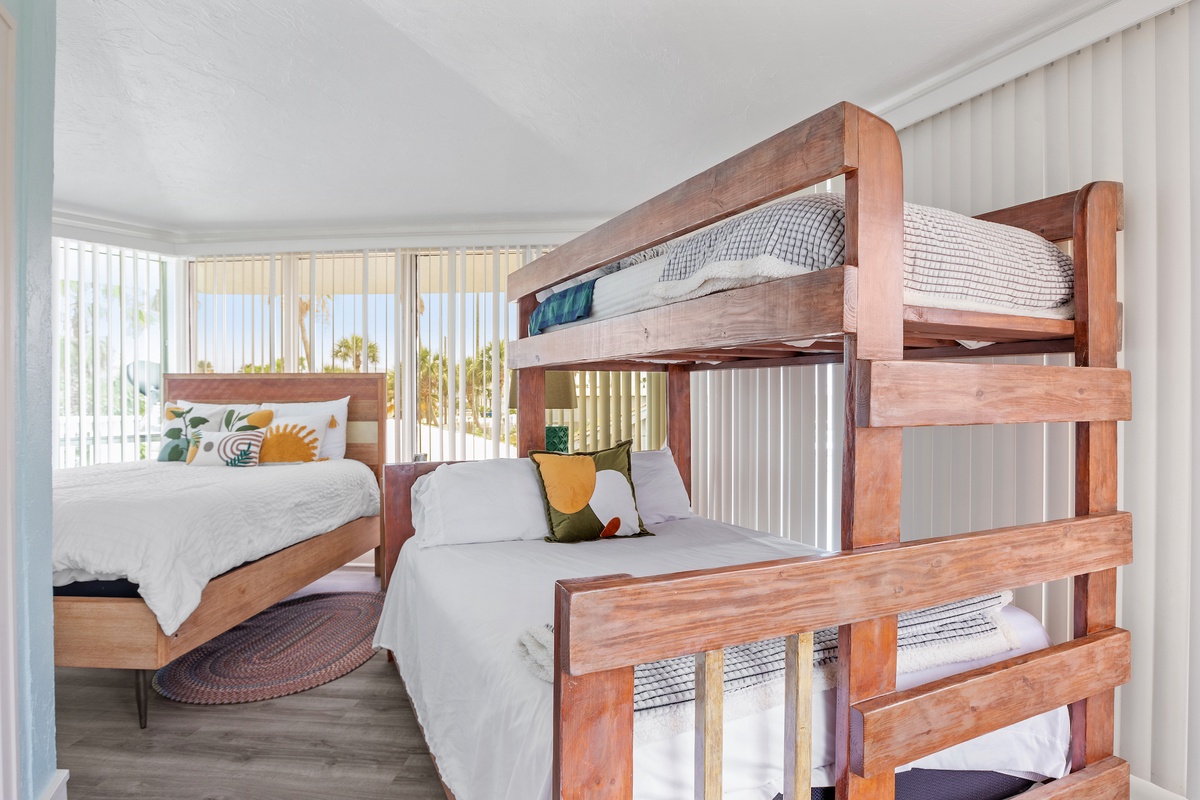 Unwind in your bright bedroom featuring custom wooden bunk beds and a cozy double bed, perfect for families or groups.