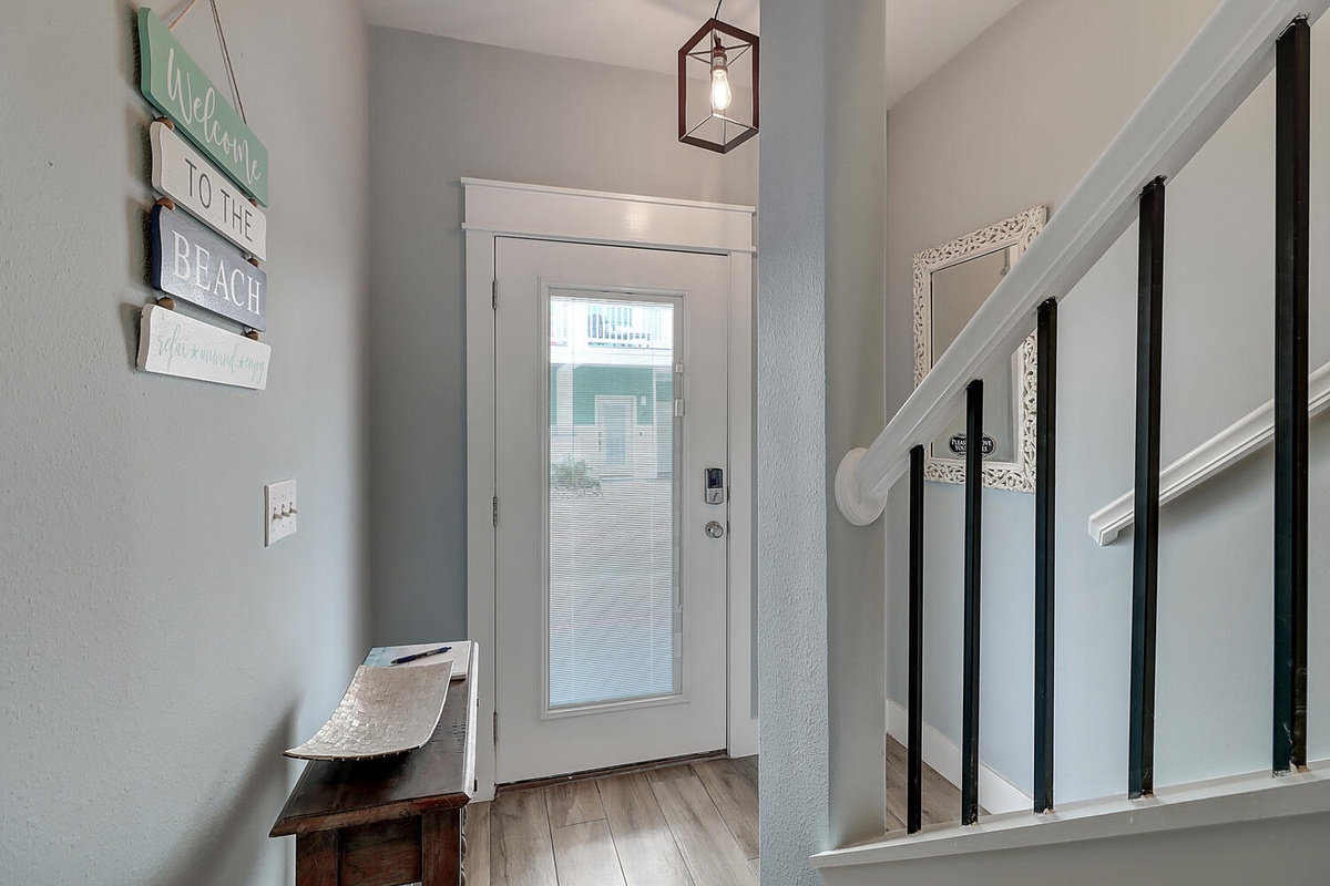 Step into your beachside retreat through this welcoming entryway, where coastal charm meets modern comfort with stylish lighting and thoughtful touches.