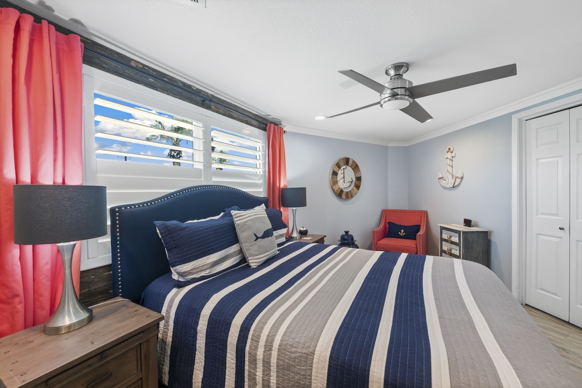 Drift off to dreamland in this nautical-themed bedroom, where navy stripes and coral curtains create a coastal sanctuary perfect for restful nights.