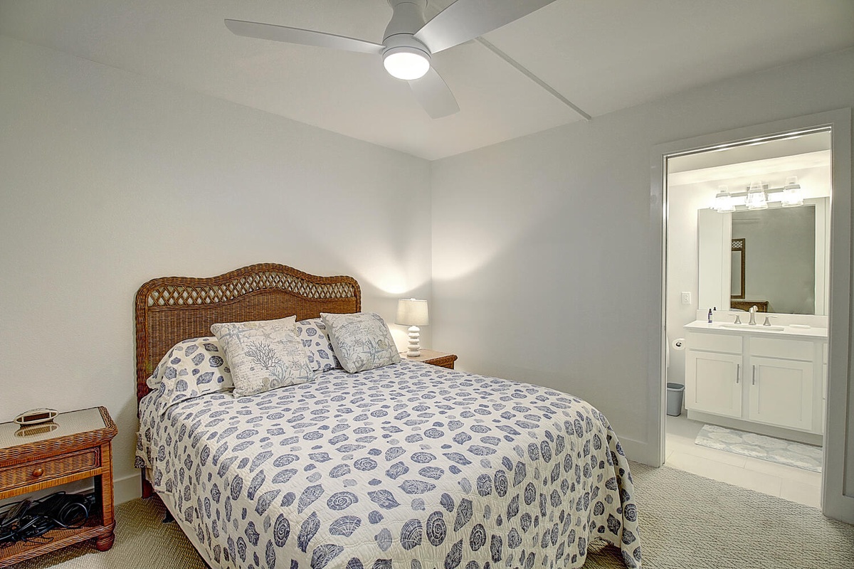 Drift off to peaceful sleep in your cozy bedroom, featuring soft linens and a gentle ceiling fan breeze with ensuite bathroom convenience.