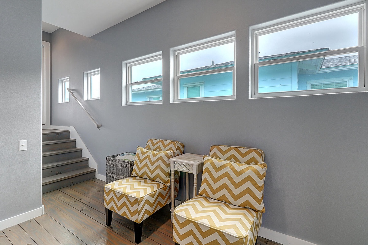Settle into your cozy reading nook with stylish chevron chairs, where natural light streams through windows creating perfect moments for relaxation.