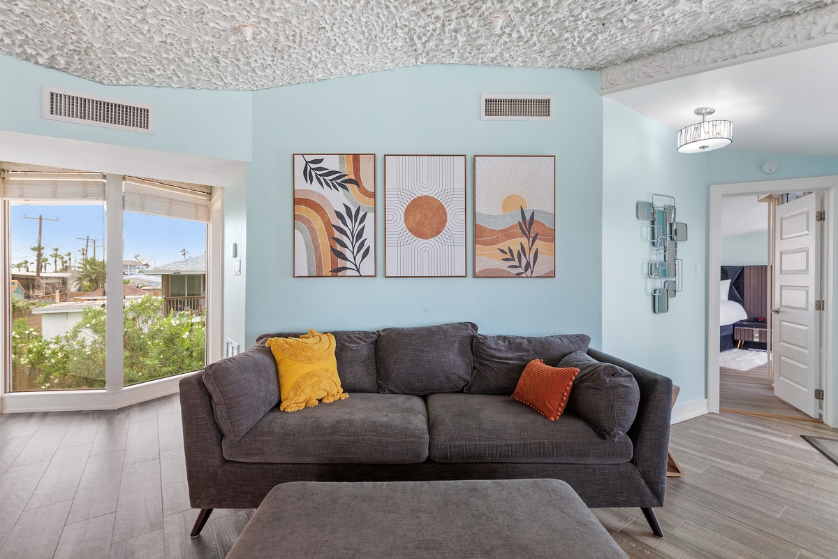 Sink into this plush sofa where natural light flows through oversized windows, creating your perfect spot to unwind and recharge.