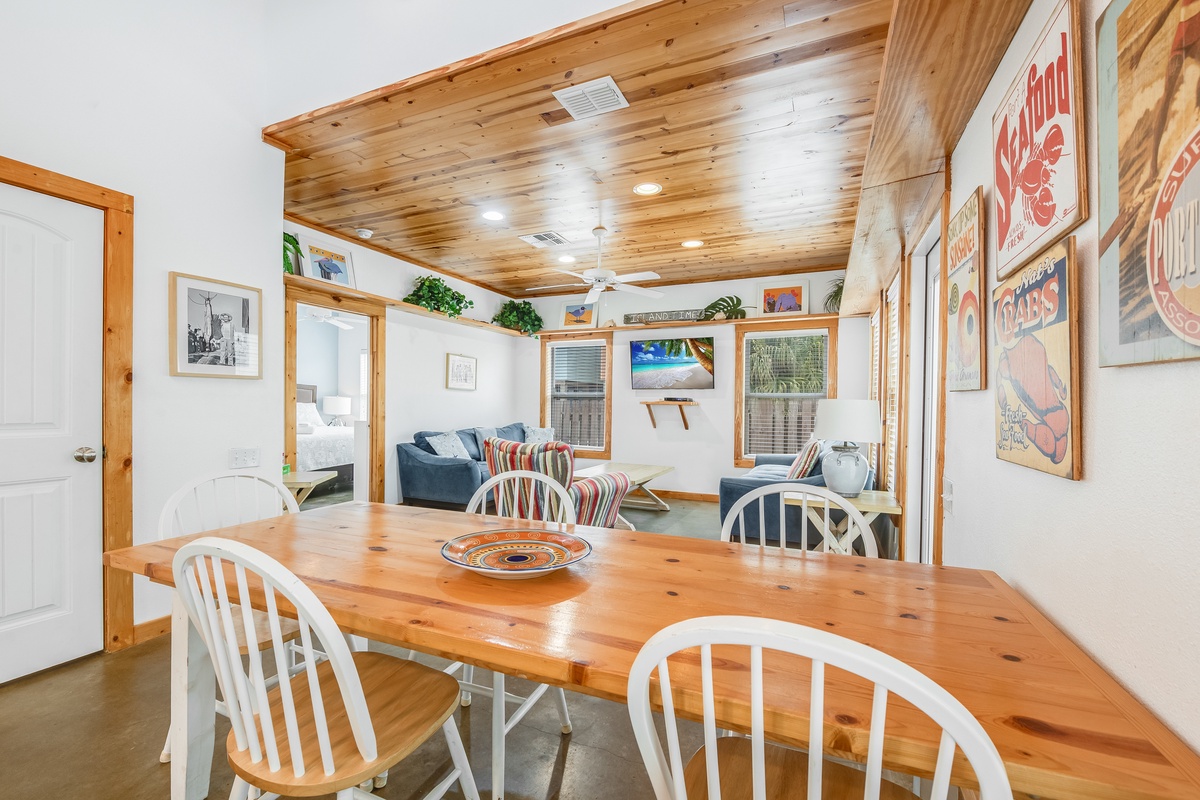 Gather around this rustic wooden table where warm conversations flow beneath beautiful exposed beam ceilings—your perfect spot for memorable meals together.