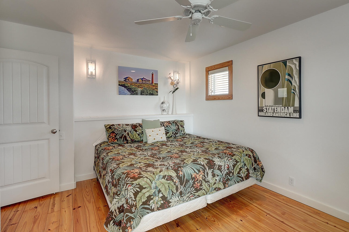 Drift into peaceful dreams in your cozy bedroom featuring tropical bedding, warm wood floors, and gentle ceiling fan comfort.
