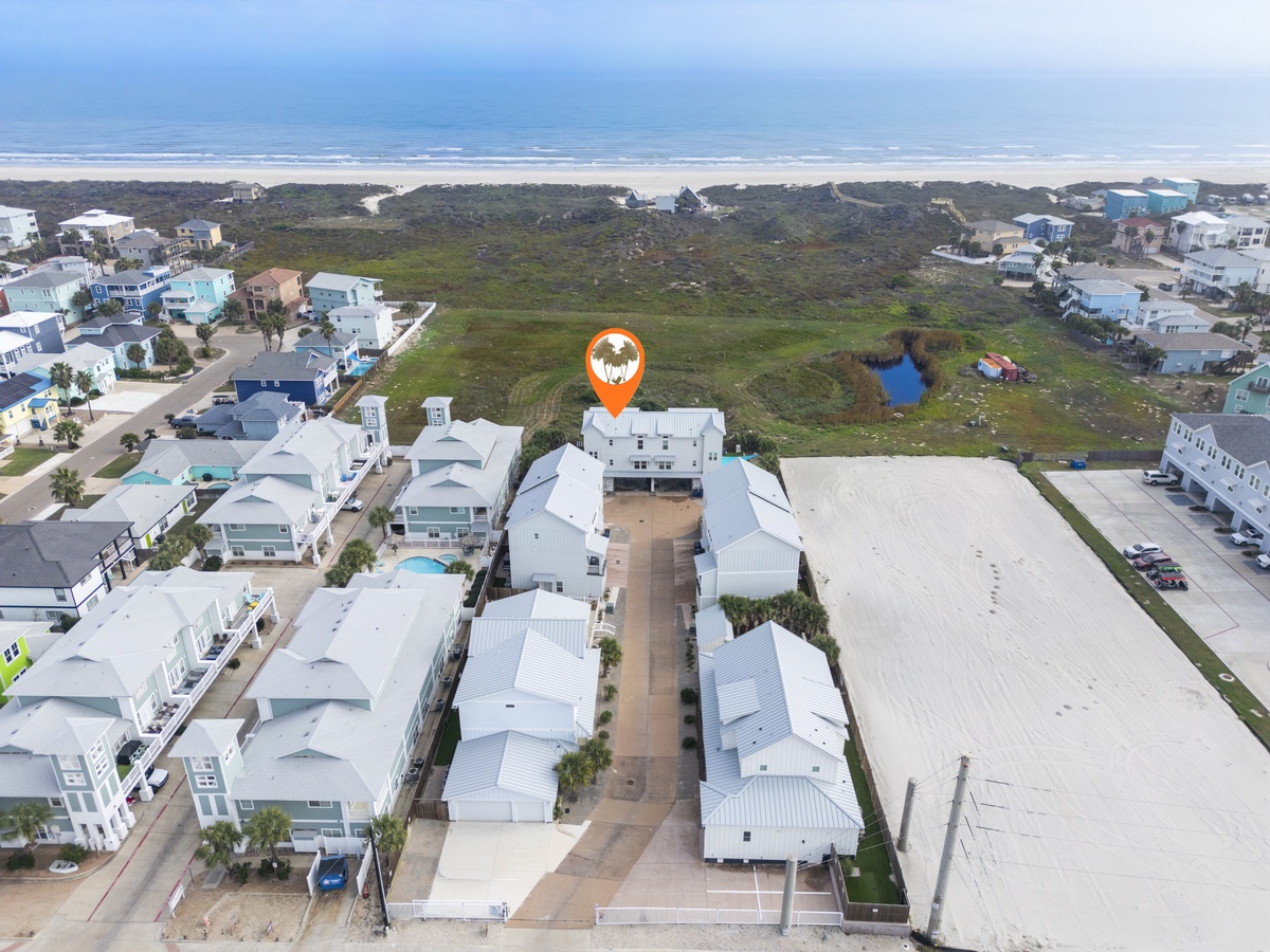 Aerial view showcasing the property's prime coastal location, with pristine beaches and natural dunes visible just beyond the residential community.