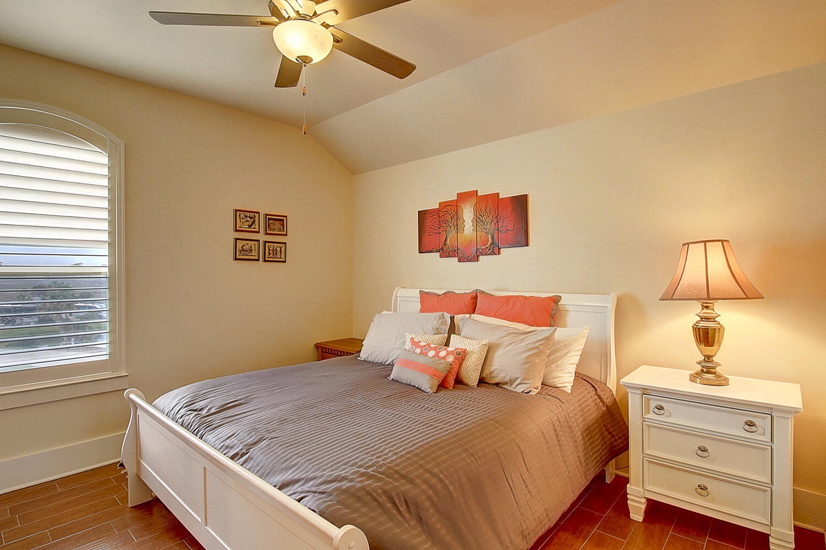 Relax in your cozy bedroom with warm coral accents, soft bedding, and thoughtful touches that create the perfect retreat.