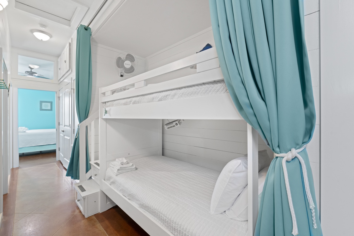 Your cozy bunk bed sanctuary offers privacy curtains and fresh linens for restful nights in this charming coastal retreat.