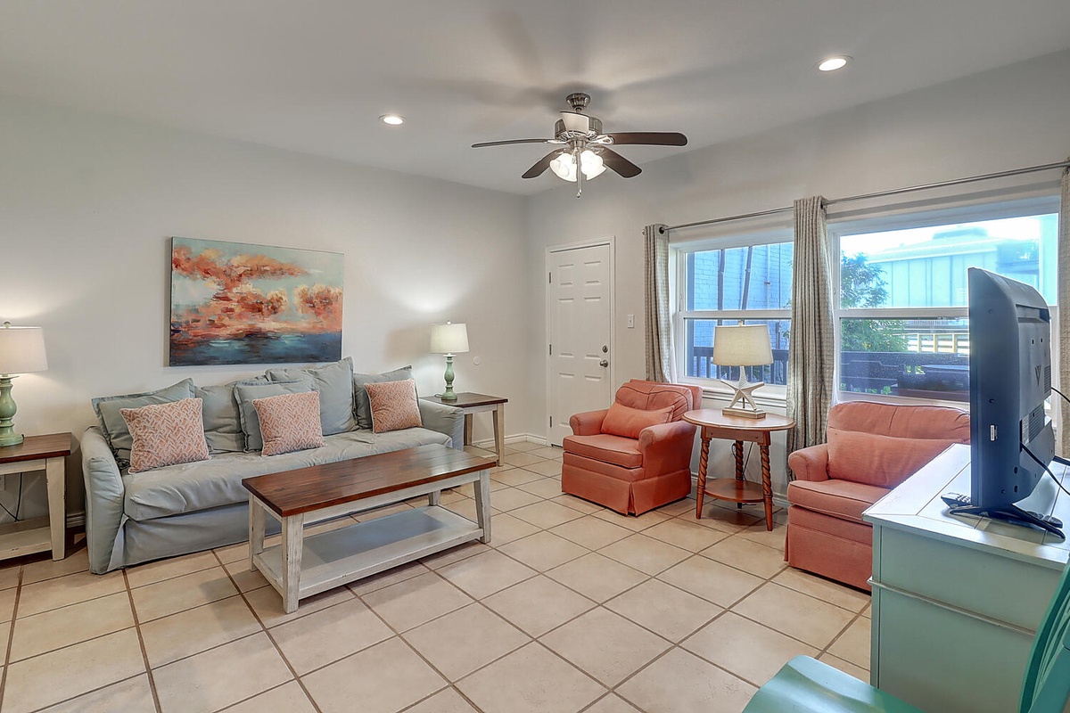 Sink into comfort in your spacious living room with plush seating and coastal charm, perfect for relaxing after beach adventures.