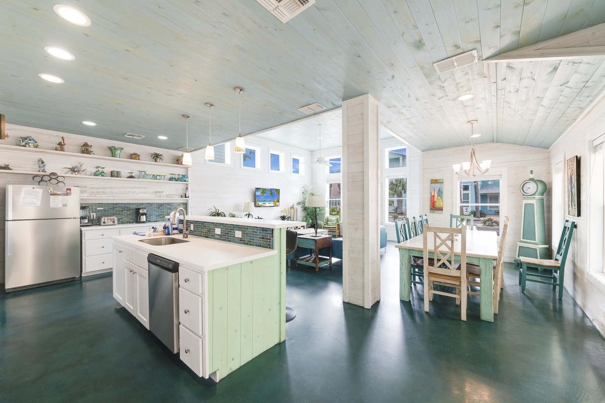 Gather with loved ones in this bright, coastal-inspired kitchen featuring a spacious island, fully equipped appliances, and charming dining area for memorable meal times.