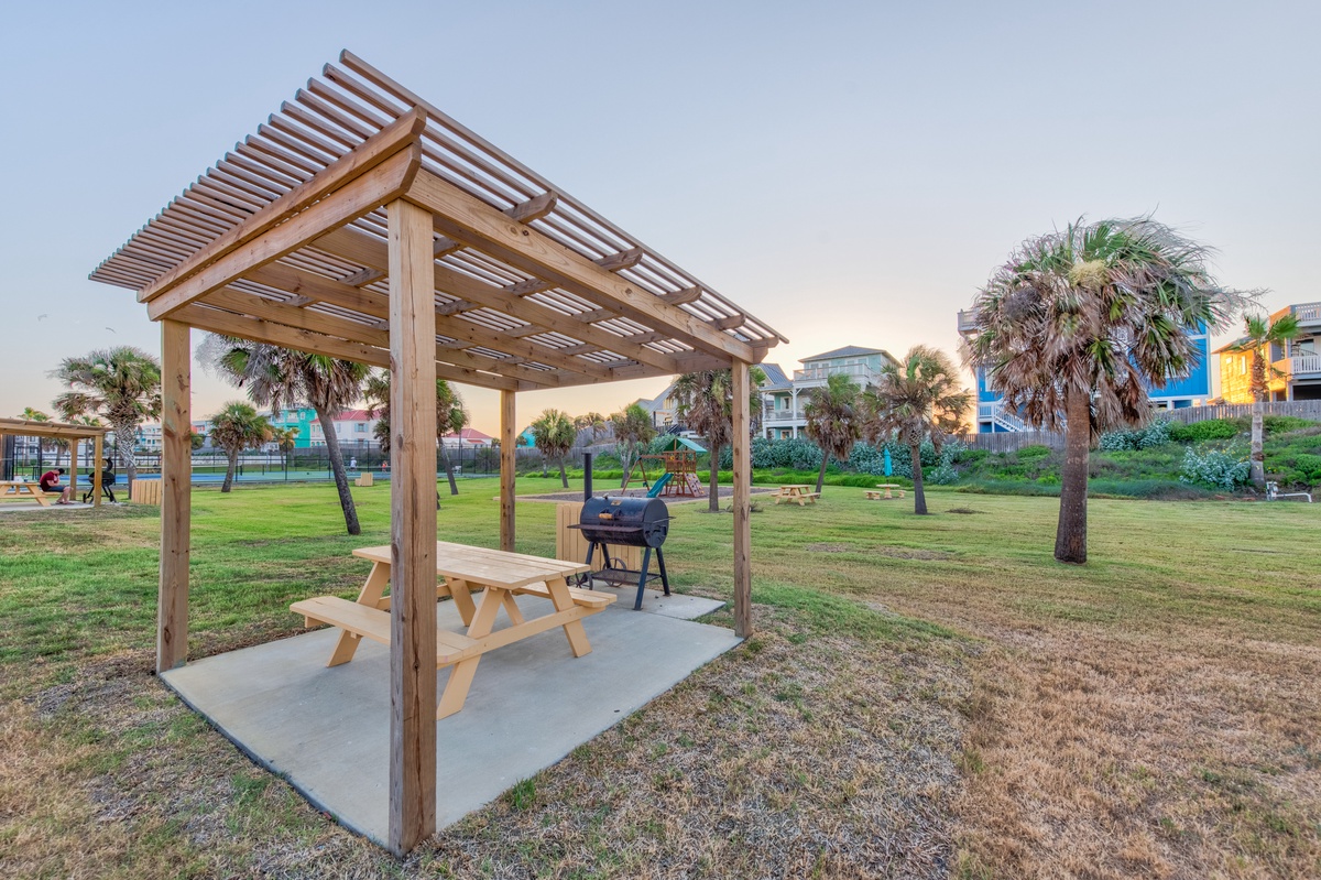 Enjoy outdoor dining under your private pergola with grilling station and picnic table, surrounded by lush tropical landscaping.