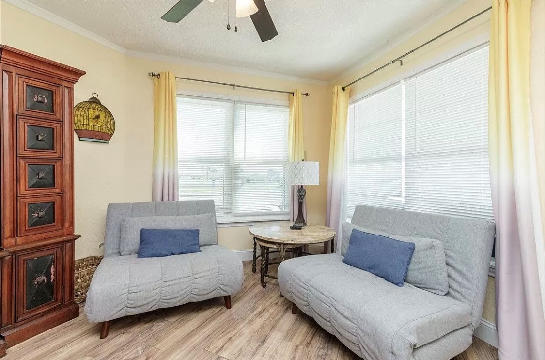 Sink into comfortable gray seating while enjoying natural light streaming through large windows in your peaceful corner retreat.