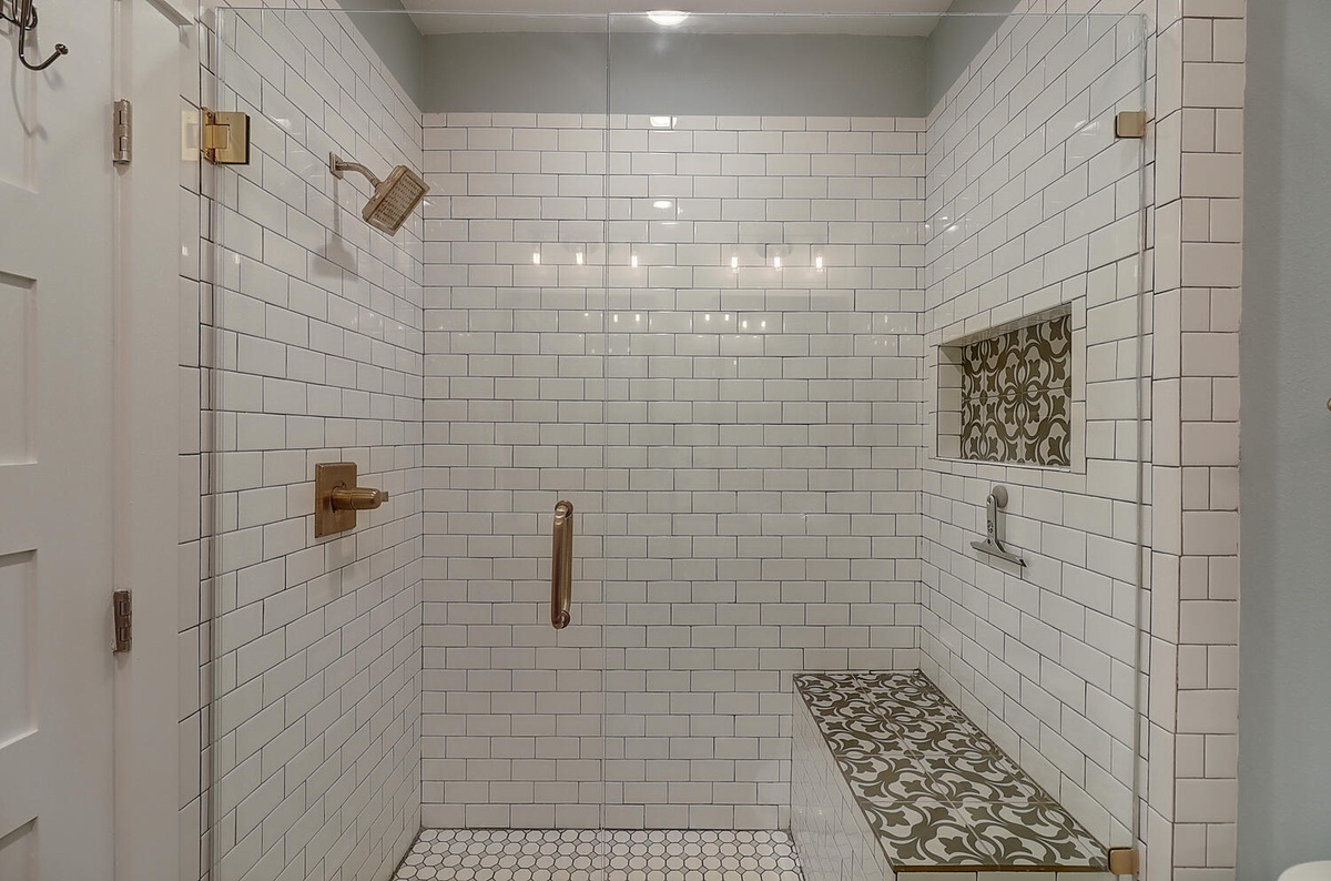 Step into your spa-like shower sanctuary with elegant subway tiles, brass fixtures, and a built-in bench for ultimate relaxation.