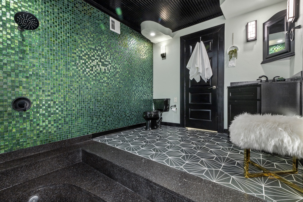 Unwind in your own spa-like sanctuary with stunning emerald mosaic walls and a luxurious soaking tub.