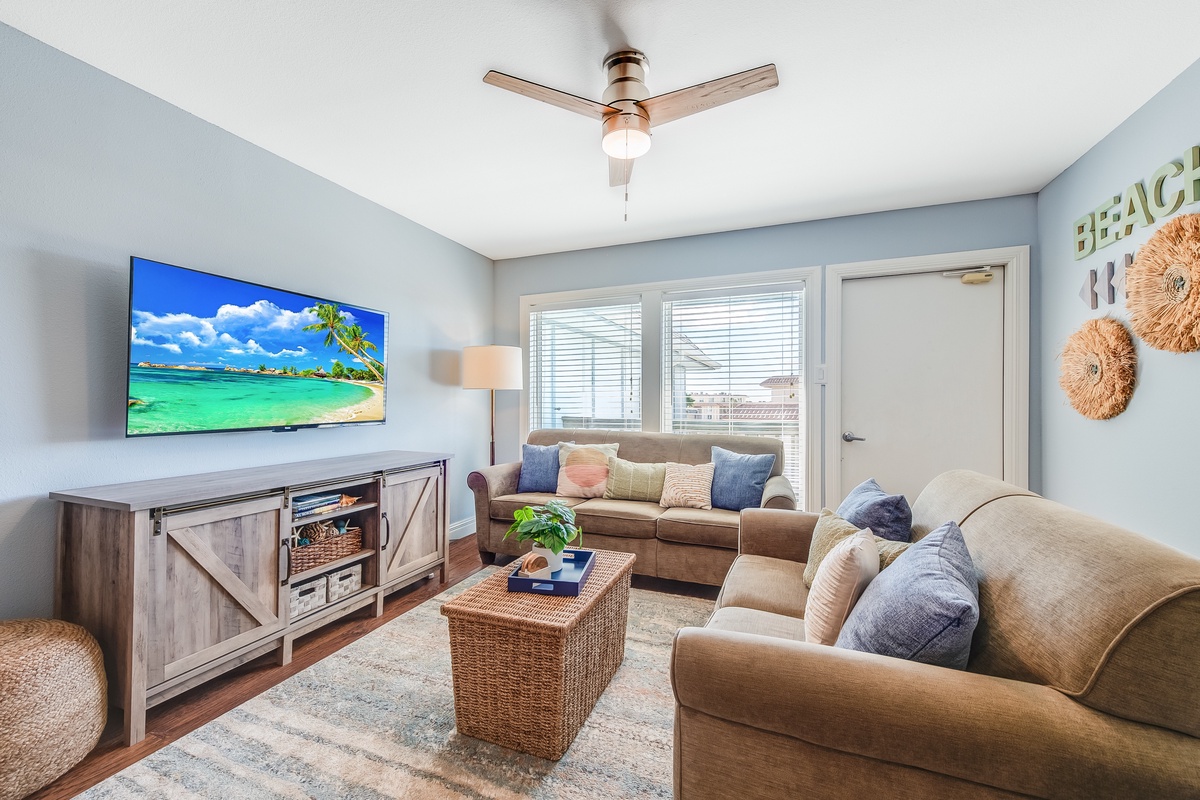 Sink into plush sectional seating while tropical breezes flow through your bright, coastal-themed living space with modern entertainment.