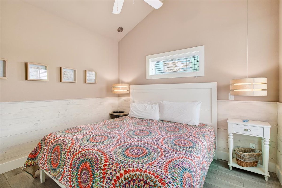 Drift off in this serene bedroom featuring soft lighting, crisp linens, and vibrant decor that creates your perfect restful retreat.