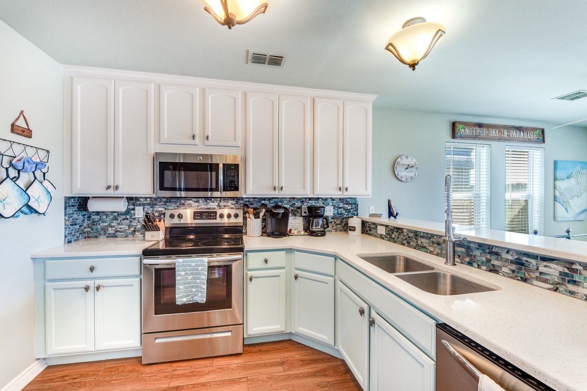 Your fully equipped kitchen awaits with coastal charm, featuring beautiful blue tile backsplash and everything needed for memorable meals.