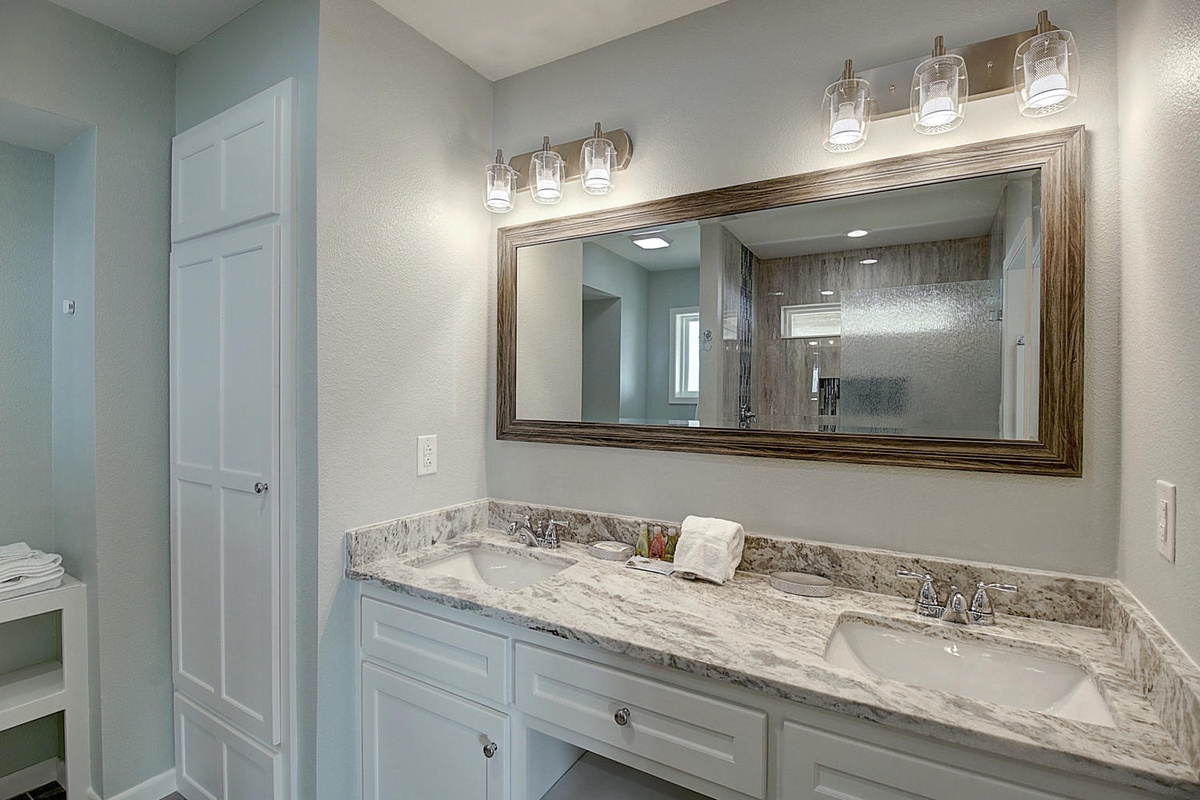 Step into your elegant master bathroom featuring dual vanities with marble countertops and beautiful lighting for your morning routine.