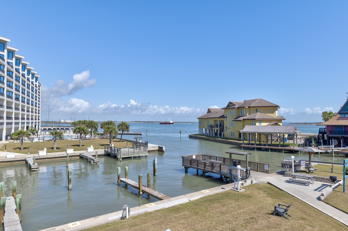 Waterfront location featuring marina, hotel building, and colorful overwater structures with fishing docks and boats nearby.