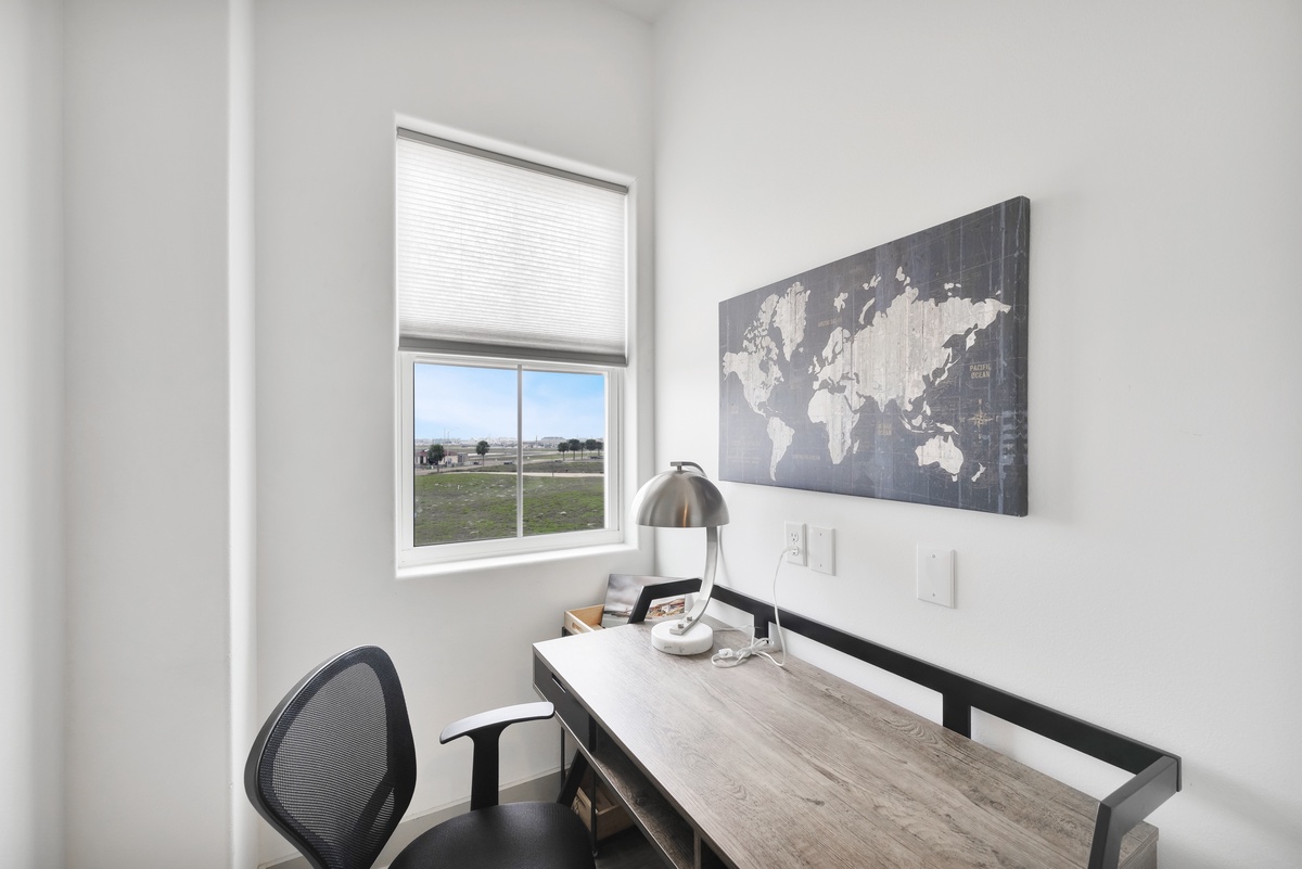 Your dedicated workspace awaits with a sleek desk, ergonomic chair, and inspiring world map—perfect for remote work or planning your next adventure.