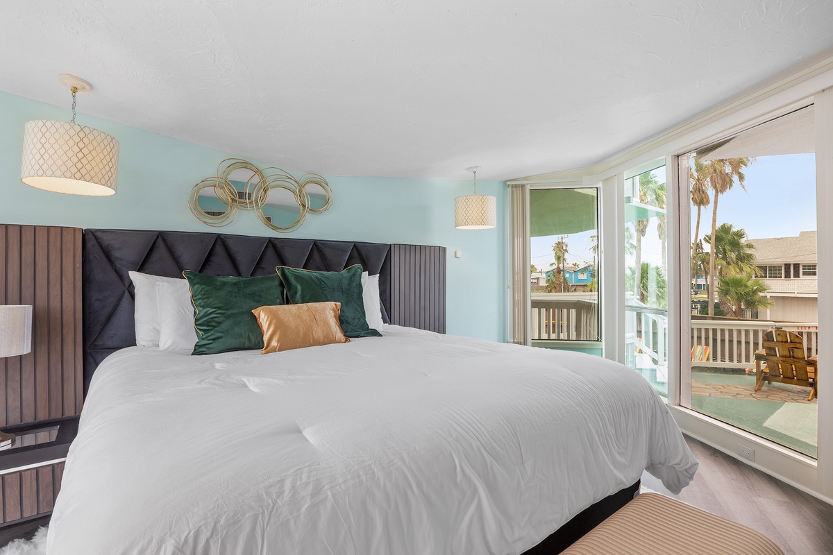 Wake up in this serene bedroom with soft linens and your private balcony overlooking palm trees and coastal charm.