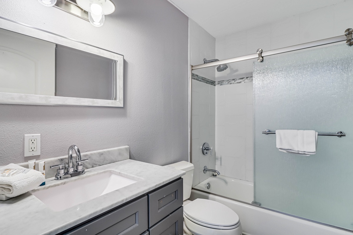 Step into your sleek, modern bathroom with marble countertops and a refreshing glass-enclosed shower.