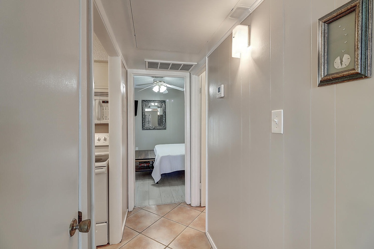 Step through this welcoming hallway where tasteful artwork and warm lighting guide you to your peaceful bedroom retreat.