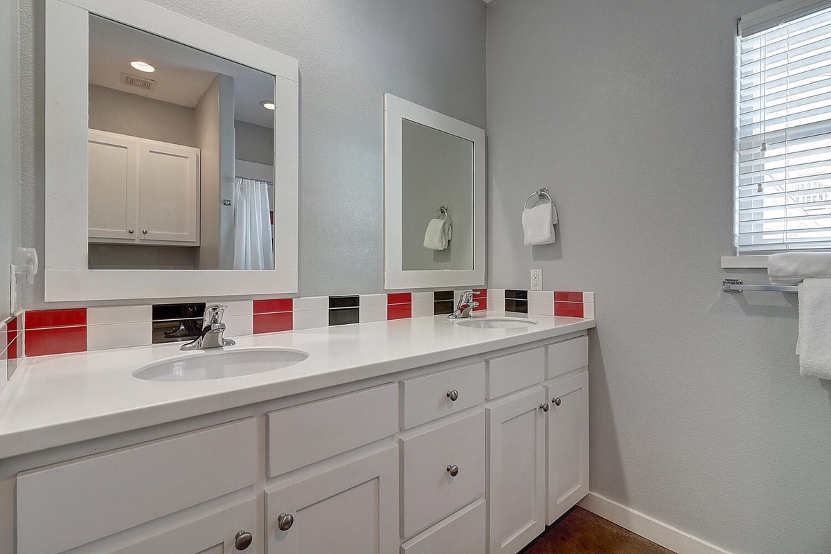 Freshen up at your spacious dual-sink vanity with bright mirrors and cheerful tile accents—perfect for sharing your morning routine.