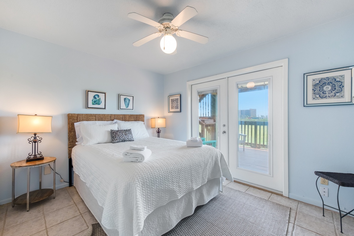 Wake up to gentle breezes from your private balcony in this serene bedroom, where crisp linens and coastal charm create your perfect retreat.