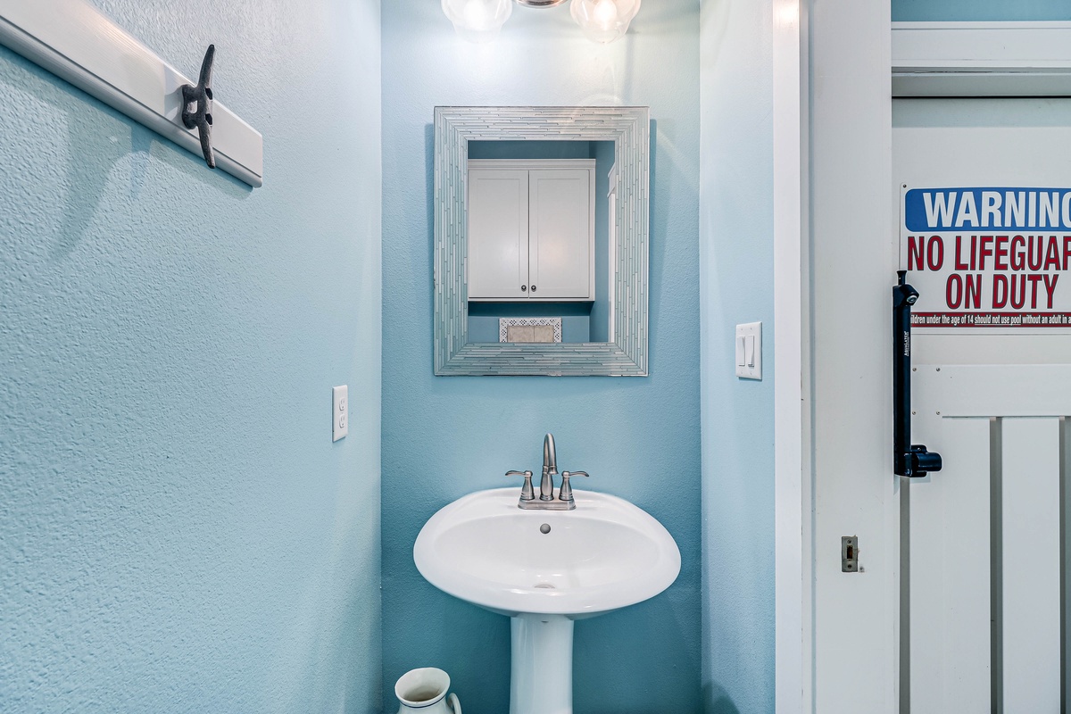 Refresh in your private powder room with coastal-inspired blue walls and bright lighting.