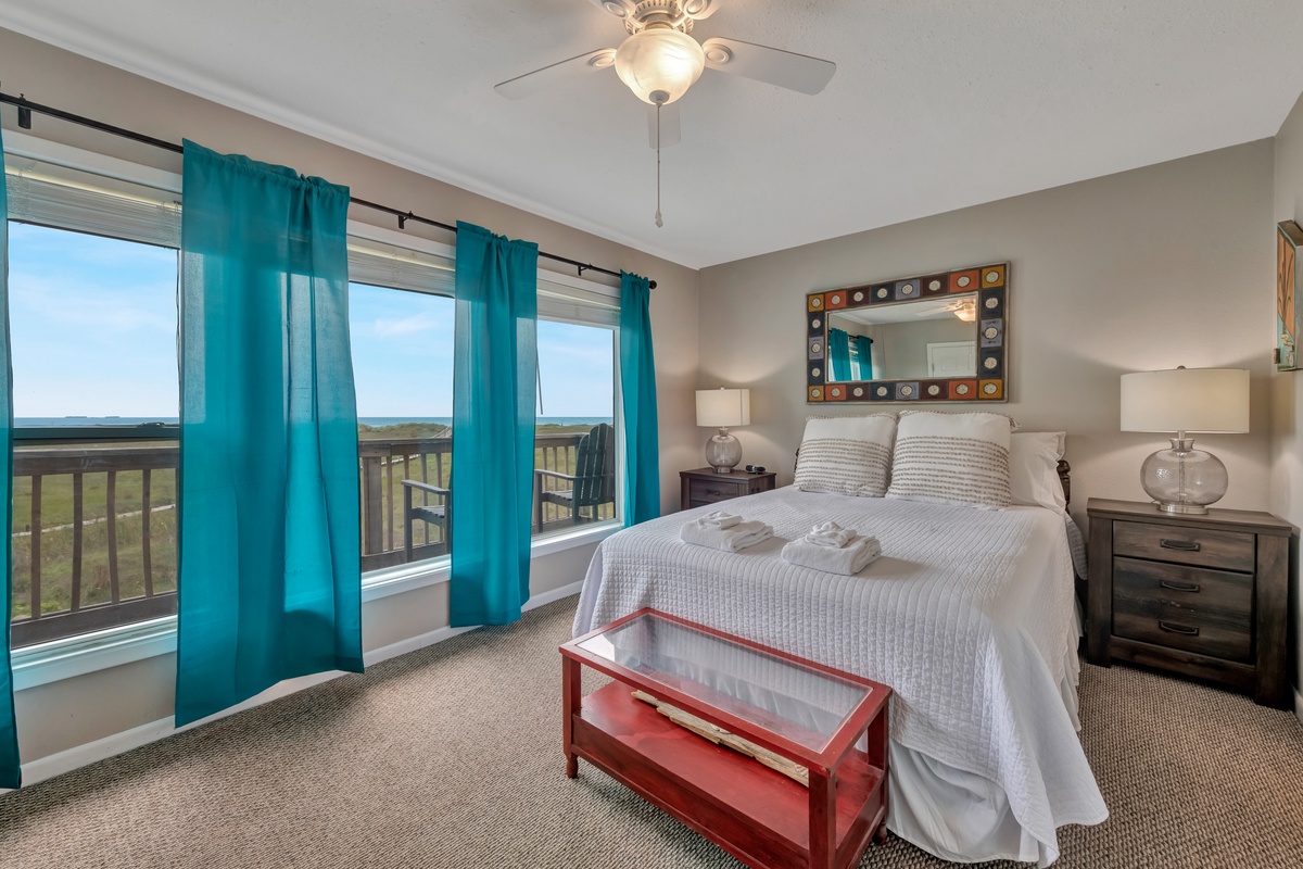 Wake up to stunning views from your comfortable bedroom, where turquoise curtains frame the horizon and fresh towels await your arrival.