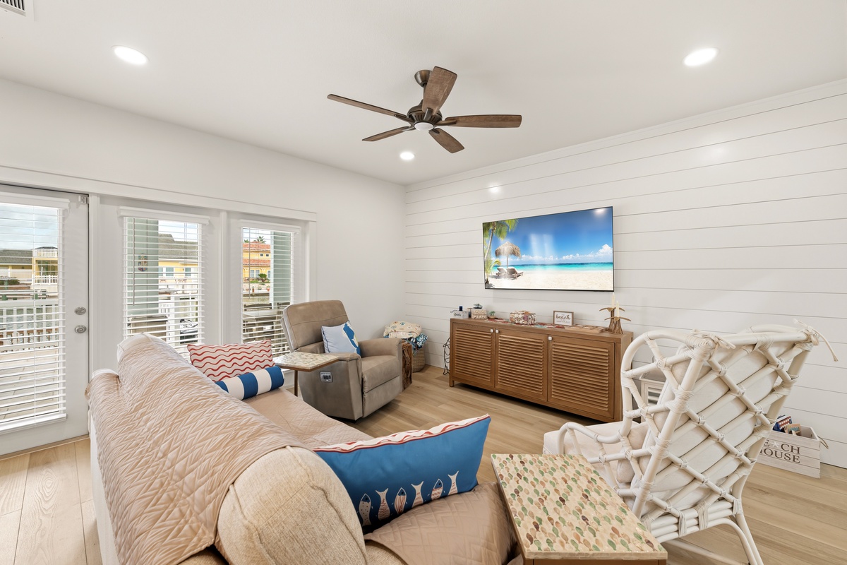 Unwind in your bright, coastal-inspired living room, where cozy seating and beach-themed touches create a relaxing retreat after days of adventure.