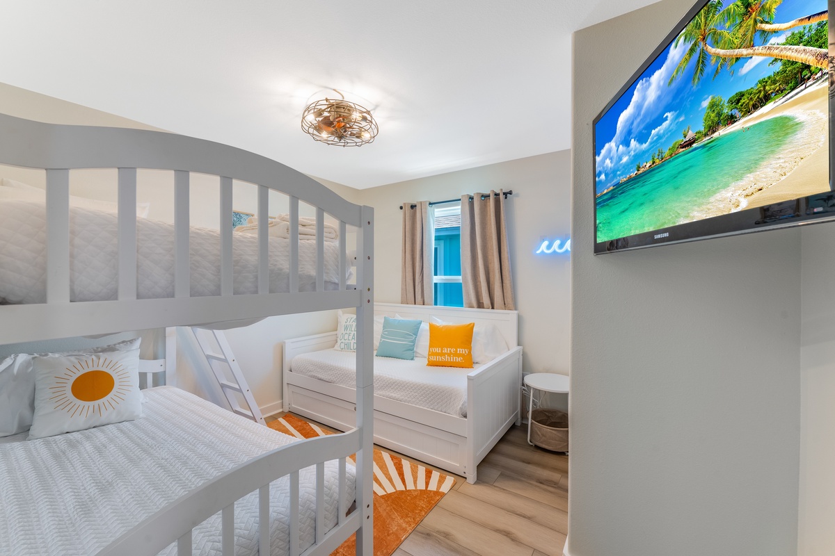 Bright, cheerful bunk room where kids can drift off watching tropical scenes on the wall-mounted TV after fun-filled days.