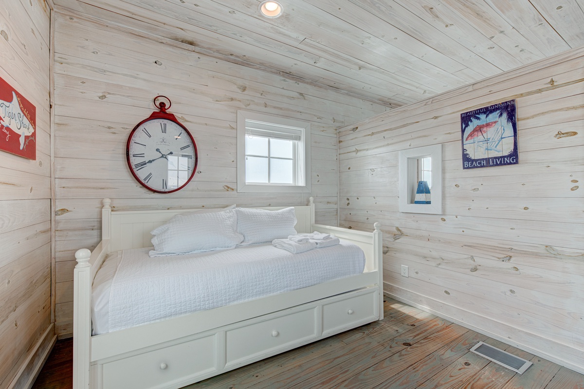 Drift off to sleep in this charming nautical bedroom with rustic wood walls and cozy daybed.