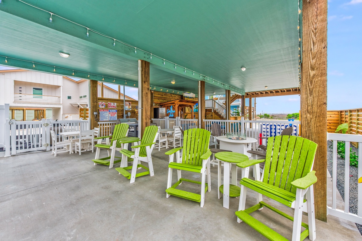 Relax in vibrant green chairs on your covered terrace, where string lights create the perfect ambiance for evening conversations.