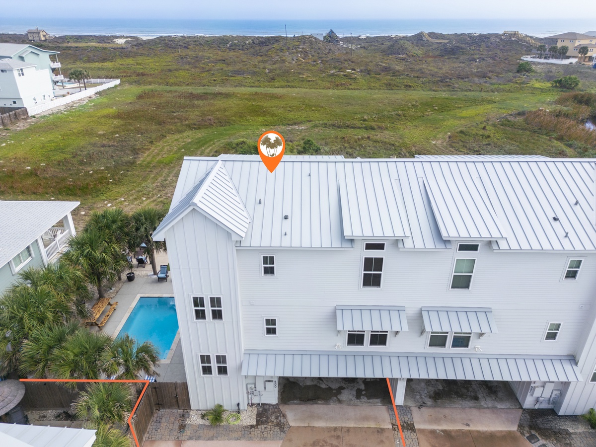 Modern coastal retreat with metal roof and private pool overlooking natural dunes and ocean views.